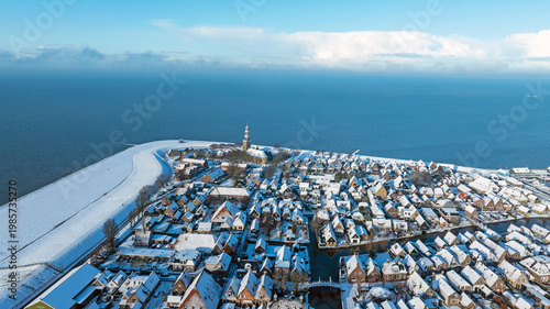 Aerial View of Small Snowy Historic Town by Lake in Winter