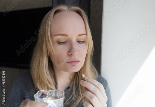 Quadro su tela Woman taking iron supplement capsule with glass of water