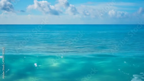 Beautiful sea waves under a clear blue sky with white clouds during a bright sunny day at the tropical beach
