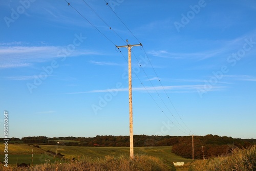 Electric grid in Northern Ireland. Wooden electric pole with glass insulators. Electricity power line.
