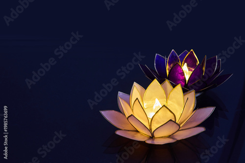 Vesak day. Floating lotus candle lanterns illuminating dark water at night