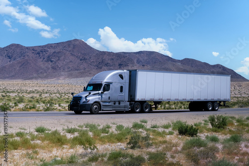 truck driving on highway through nature and mountains. Commercial vehicle transport for logistics and  shipping.