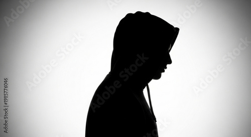 Silhouette of a person wearing a hooded sweatshirt representing anonymity and mystery isolated on a white background