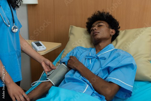 The patient is having their blood pressure measured in a hospital bed.