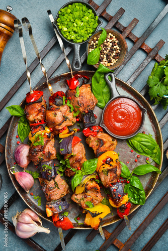 Kebabs - grilled meat skewers, shish kebab with vegetables on a plate. On a concrete old table. Top view.