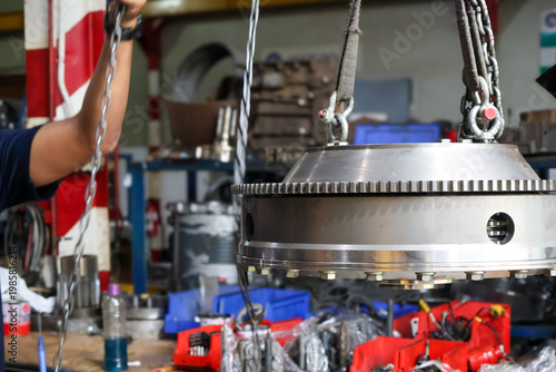 Принти на полотні Close up of a heavy steel flywheel being lifted by a chain hoist