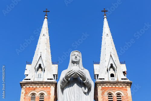 Statue of the Virgin Mary standing in front of the Notre Dame Cathedral Basilica of Saigon in Ho Chi Minh City, Vietnam.