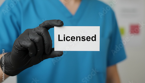 Medical professional holds Licensed card, wearing blue scrubs and black gloves. Healthcare professional shows authorization for service, confirming medical practice.  Healthcare and Professional Servi