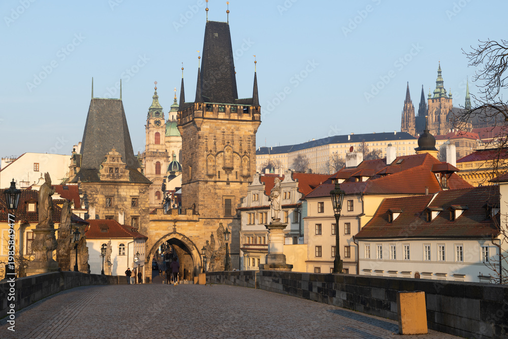 Fototapeta premium scenic view of Prague Castle and Charles Bridge glowing in golden light over the Vltava River