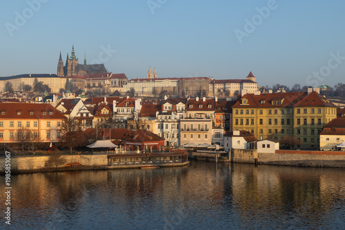 scenic view of Prague Castle and Charles Bridge glowing in golden light over the Vltava River
