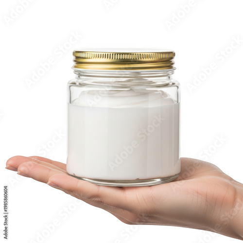 Glass jar with a gold lid held by a hand isolated on white background