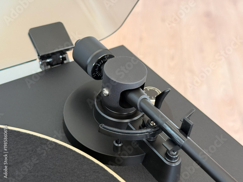 Quadro em tela Top view close-up of a modern matte black turntable tonearm assembly, showcasing the counterweight and precision tracking force adjustments