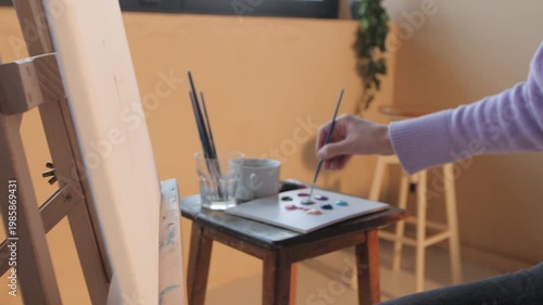 Woman artist painting on canvas with brush
