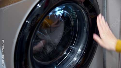Dirty laundry placed inside washing machine, visible through glass door