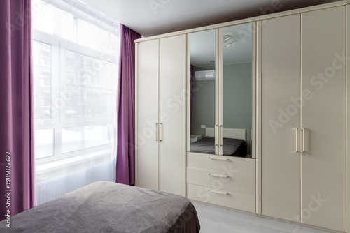 Bright minimalist bedroom interior with wardrobe and large window, modern apartment. Template, 3D render