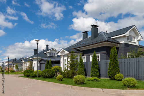 Modern suburban houses with landscaped yard and blue sky, premium real estate