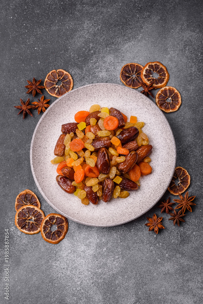 Fototapeta premium Dried apricots, raisins, and candied fruits as ingredients for baked goods and sweets. Dried fruits