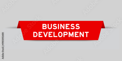 Red color inserted label with word business development on gray background