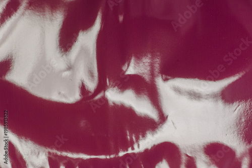 Pink glossy plastic foil texture with strong light reflections