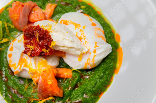 Poached eggs with salmon, spinach, and sun-dried tomatoes on a plate