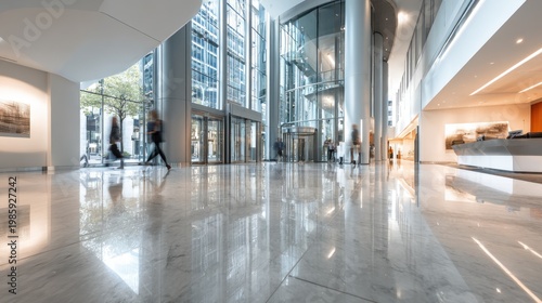Modern office lobby with polished marble floors and blurred people walking. A bright and spacious corporate reception area featuring reflective marble flooring and glass architecture