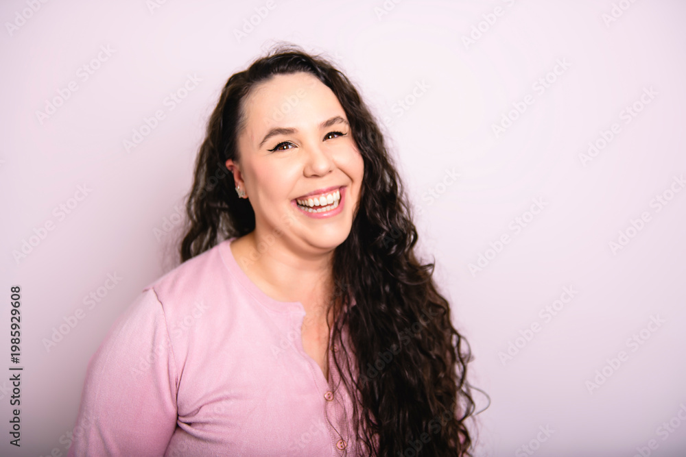 Fototapeta premium Long brown haired European woman isolated over white background. Cheerful female model poses in studio