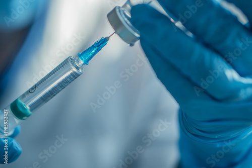 A gloved hand draws liquid from a vial into a syringe, symbolizing vaccination and healthcare safety. This photo emphasizes immunization, prevention, and medical innovation