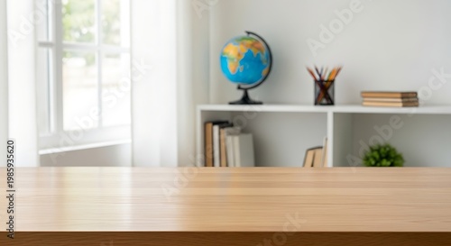 A wooden table in a bright and airy room with a bookshelf and globe in the background with a window to the left