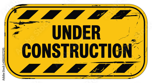 A weathered yellow sign displays the warning under construction in bold lettering