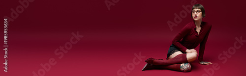 Fotografía Young woman in stylish outfit exudes confidence against a vibrant red backdrop