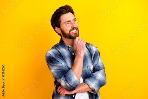 Quadro su tela Thoughtful smiling man in plaid shirt looking up on bright yellow background — c