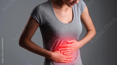 A woman holds her stomach in pain, symbolizing health challenges and the impact of discomfort on daily life.