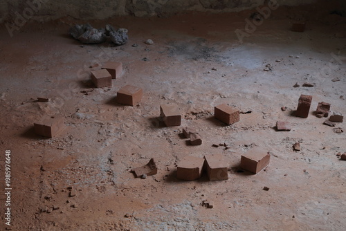 Broken bricks on the concrete floor.  Construction debris.