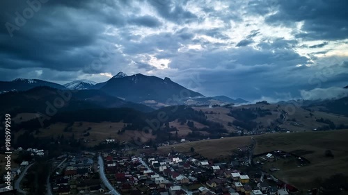 Aerial hyperlapse of a scenic mountain village and moving clouds