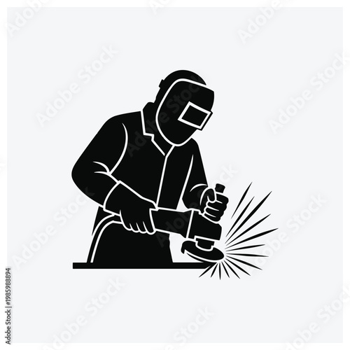 Silhouette of a worker polishing metal with sparks