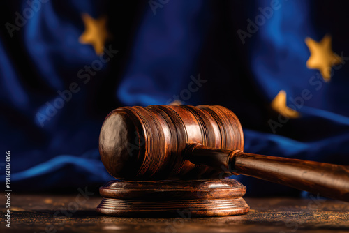 Close-up of a wooden judge gavel on a sound block with a blurred European Union flag, symbolizing justice, EU law, and legal regulation.