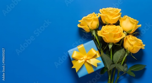 Father's day gift vibrant yellow roses and present on a bright blue background