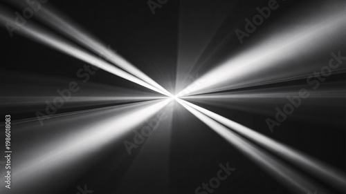 A dramatic black and white photo of light rays shining brightly in a dark space