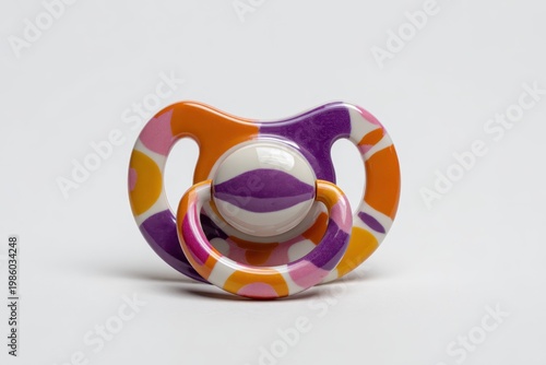 a colorful pacifier with a purple and orange design on a white background