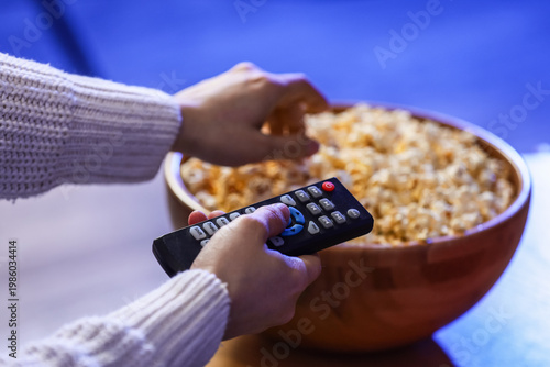 Female hands with TV remote...