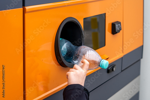Tableau sur toile Hand putting plastic PET bottle into a modern recycling vending machine, deposit return system and waste segregation, eco-friendly urban solutions, environmental protection and plastic recovery