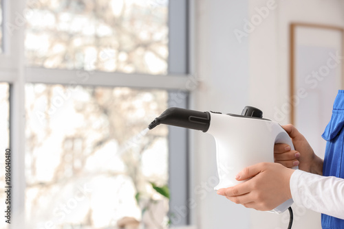 Female janitor with steam c...