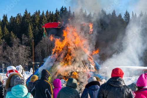 Fotografie Crowd gathers to watch a straw effigy burn at the Maslenitsa festival