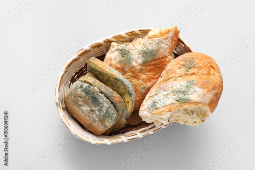 Konstfotografi Wicker basket with moldy bread on blue background