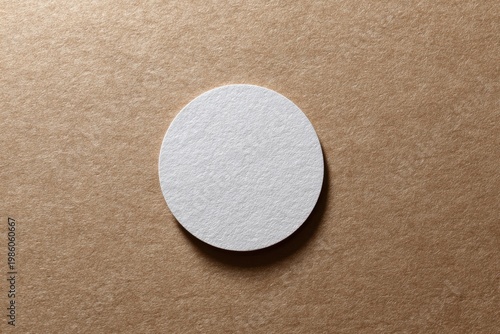 Textured white oval paper on brown cardboard background