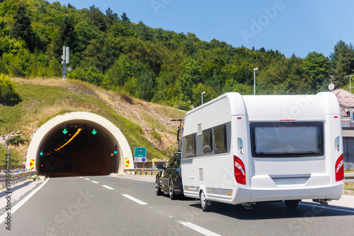 Scenic view big modern white family rv camper van vehicle drive Europe highway road alpine mountain cloud in summer day. Rving motorhome lifestyle travel and adventure tourism trip journey concept
