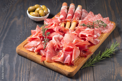 Charcuterie board. Antipasti appetizers of meat platter with salami, prosciutto crudo or jamon and olives.