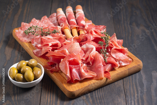 Charcuterie board. Antipasti appetizers of meat platter with salami, prosciutto crudo or jamon and olives.