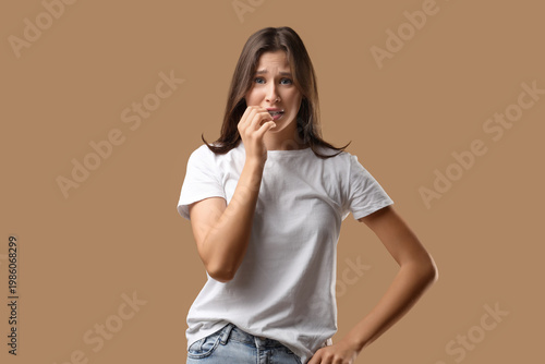 Scared young woman on beige...