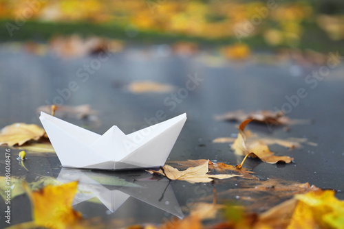 Paper boat with autumn leav...